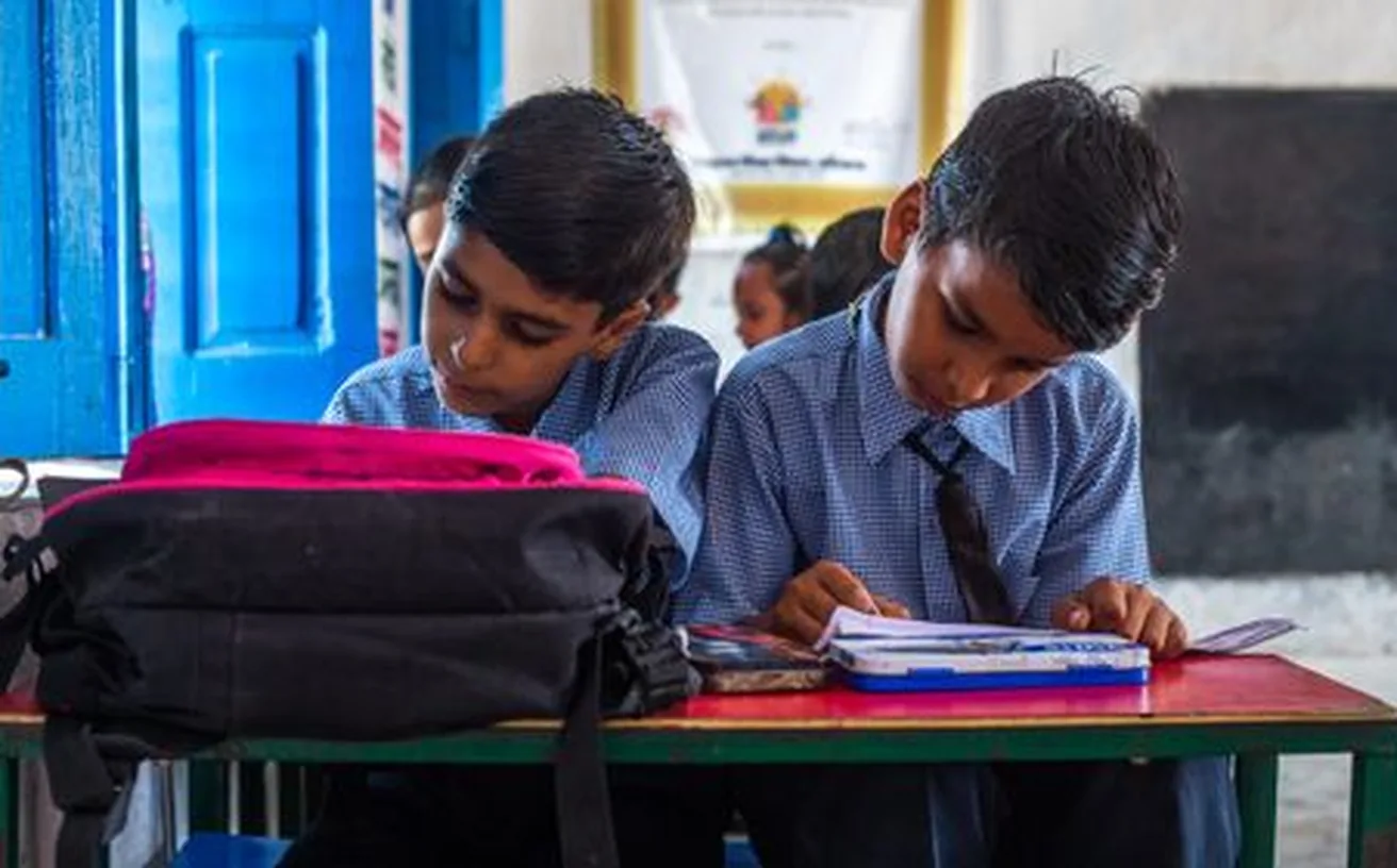 Indian school students in uniform studying at a desk